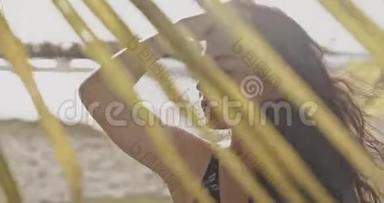 美丽的女孩，皮肤晒黑的姿势和行走在热带植物。 在<strong>佳能</strong>相机上拍摄12位颜色深度。